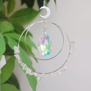 Detailed view of handmade metal moon crystal suncatcher with iridescent teardrop pendant