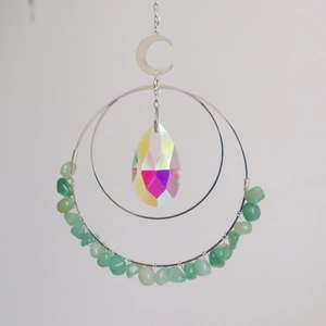 Detail of moon crystal suncatcher featuring green stones and iridescent waterdrop prism