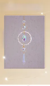 Detail of crystal suncatcher with moon pendant and golden geometric frame hanging
