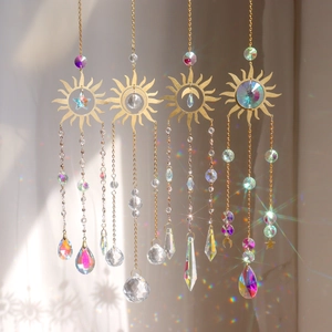 Detail of golden sun-shaped suncatchers with K9 crystal prisms and metallic chains