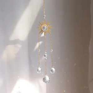 Macro detail of sun catcher showing golden sun metal plate and crystal balls reflecting rainbows