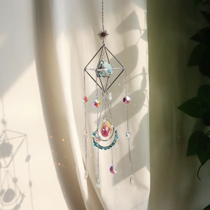 Λεπτομέρεια γεωμετρικού suncatcher με μπλε πέτρα και κρυστάλλινο πρίσμα δακρύων
