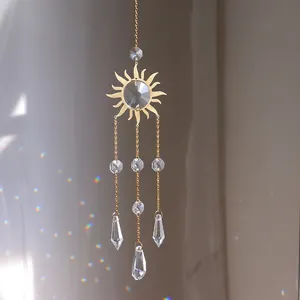 Detailed close-up of golden sun-shaped crystal suncatcher with hanging prisms
