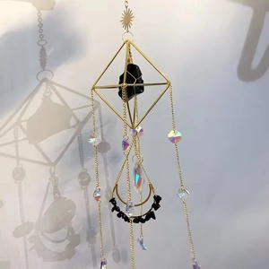 Detail of geometric suncatcher with golden metal frame, amethyst stone and crystal beads