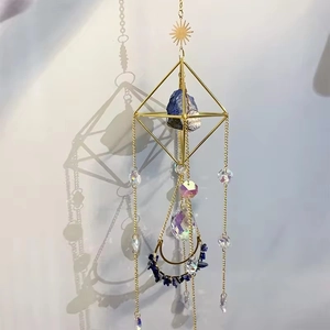 Detail of suncatcher with amethyst crystal moon pendant and golden metal frame