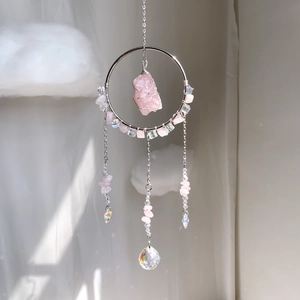Detailed close-up of handmade pink crystal suncatcher with metal ring and facets