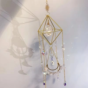 Close-up of geometric crystal suncatcher with natural quartz and golden celestial charms