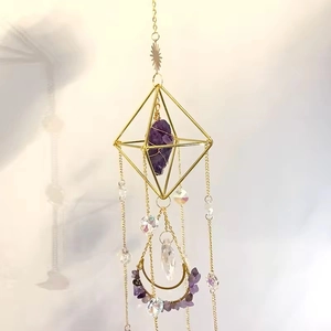 Close-up of diamond-shaped suncatcher with natural amethyst and gold geometric frame