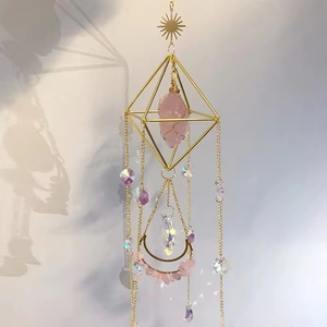 Detail of pink crystal suncatcher with golden diamond frame and lunar stone pendant