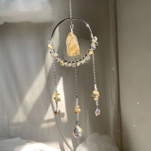 Macro detail of suncatcher crystal ball and yellow quartz stone reflecting rainbow light
