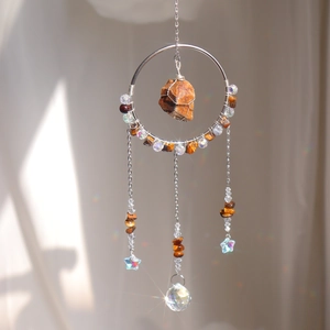 Detail of tiger eye stone suncatcher with crystal prisms and hanging metallic chains