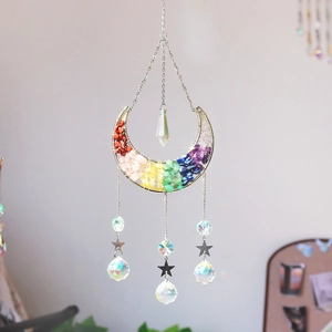 Macro detail of moon-shaped suncatcher with rainbow crystals and star pendant