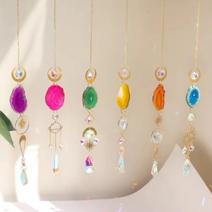 Colorful agate slice suncatchers with crystal prisms and golden moon charms hanging indoors