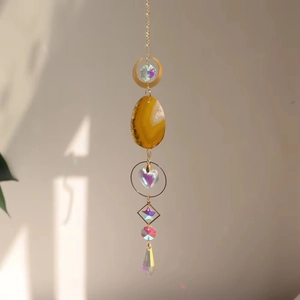 Detail of bohemian suncatcher with yellow agate slice and rainbow crystal prisms