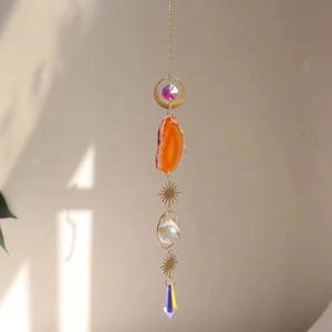 Close-up of bohemian suncatcher with orange agate slice and colorful prism crystals