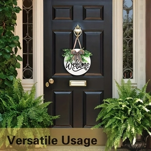 Detail of wooden welcome sign with buffalo plaid bow and greenery on black front door