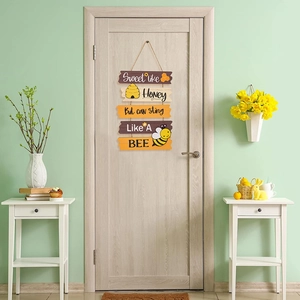 Dettaglio della targa in legno ape con girasoli e scritte decorative sul miele dolce