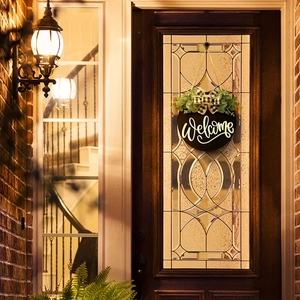 Détail d'une plaque de bienvenue noire sur porte avec eucalyptus et nœud à carreaux décoratif