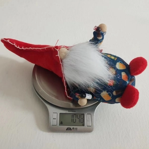 Detail showing plush patriotic gnome figurine being weighed on a digital scale at 104.8g