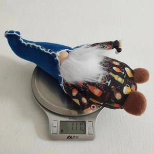 Detailed view of beer-themed plush gnome ornament on an electronic scale showing 111.0g weight