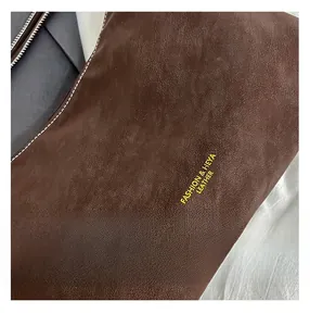 Nahaufnahme der braunen Leder-Tote-Bag mit Kieselstruktur und goldenem Logo-Druck