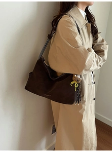 Detailansicht der großen dunkelkaffeebraunen Hobo-Tasche mit Goldlogo und Bärenanhänger