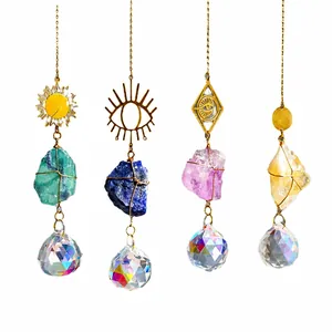 Set of four crystal suncatchers with natural raw stones and golden metal sun symbols