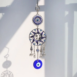 Detail of blue evil eye suncatcher with metal elephant charms and sun moon design