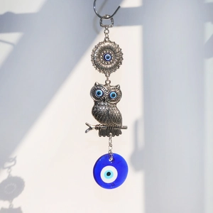 Detailed view of silver tree of life suncatcher with blue evil eye glass and owl charm