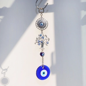 Detail of evil eye suncatcher with tree of life metal disc and blue glass charm