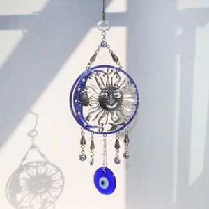 Detail of silver metal sun and moon wall hanging with blue evil eye glass charms