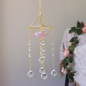 Detailed view of suncatcher showing golden geometric frame and purple amethyst crystal core