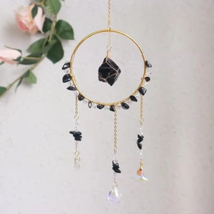 Detail of handmade suncatcher with black crystals and a shimmering glass prism pendant