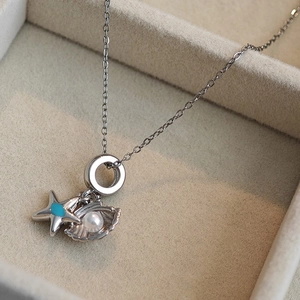 Collier argenté style océan avec pendentif étoile de mer et perle sur boîte à bijoux