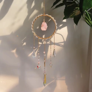 Crystal suncatcher with rose quartz and butterfly hanging in natural sunlight