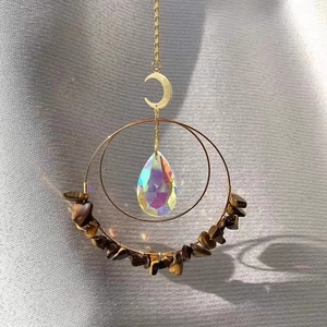 Detail eines Mond-Sonnenfängers mit goldenen Metallringen und Tigerauge-Steinen