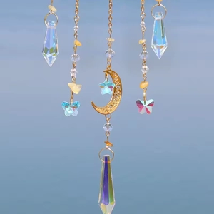 Detail of suncatcher featuring golden crescent moon and colorful crystal prisms