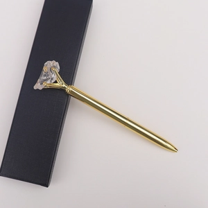 Vue détaillée d'un stylo en métal doré avec une pierre de cristal blanc naturel et coffret cadeau