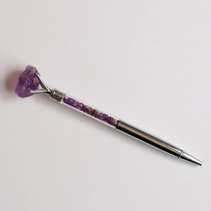 Vue détaillée du stylo argenté en cristal rempli de pierres d'améthyste violettes