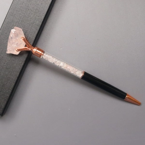 Detail eines kreativen schwarzen Kugelschreibers mit rosa Kristallen und Roségold-Spitze