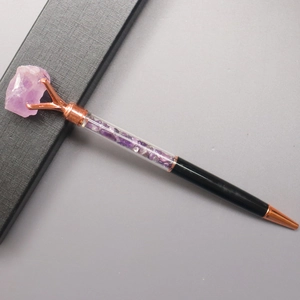 Detail eines roségoldenen Kugelschreibers mit lila Amethyst-Kristallen und Geschenkbox