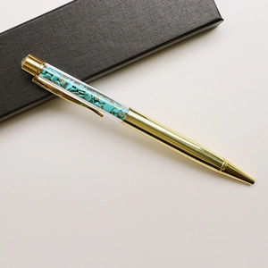 Golden crystal ballpoint pen filled with turquoise stones in a black luxury gift box