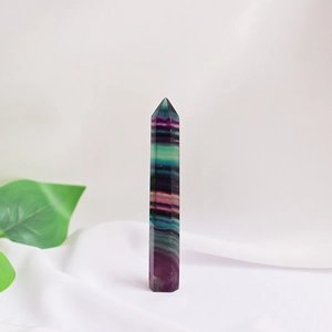 Macro detail of natural fluorite crystal wand with purple and green bands on white fabric