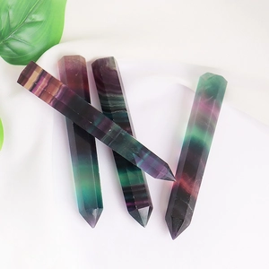 Polished natural fluorite crystal points with purple and green textures on white background