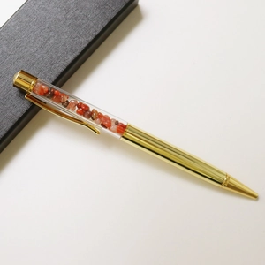 Detail of a gold crystal ballpoint pen with brown crushed stones in a black gift box