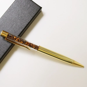 Golden luxury ballpoint pen with brown crystal stones in a textured black gift box
