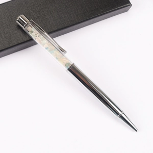 Detail of silver metal ballpoint pen with colorful natural crystal stones in clear tube