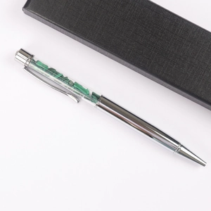 Silver ballpoint pen with green crystal stone fragments inside and a black gift box
