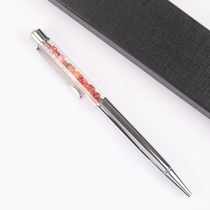 Detail of silver metal ballpoint pen with red crystal stones and black gift box