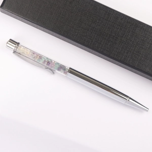 Close-up of silver metal crystal pen with colorful crushed stones and black gift box